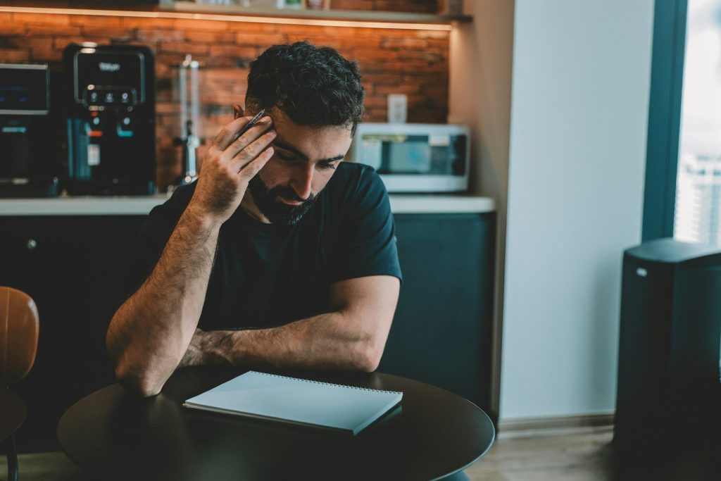 Man holding head while looking at document